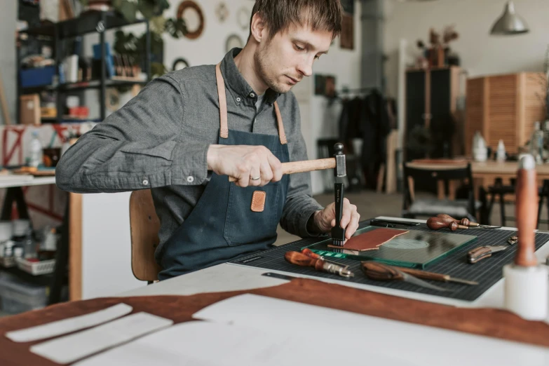 a man sitting at a table working on an object