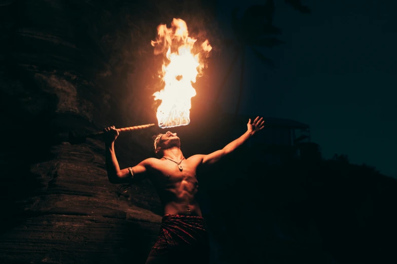 a man with fire staff lit in the dark