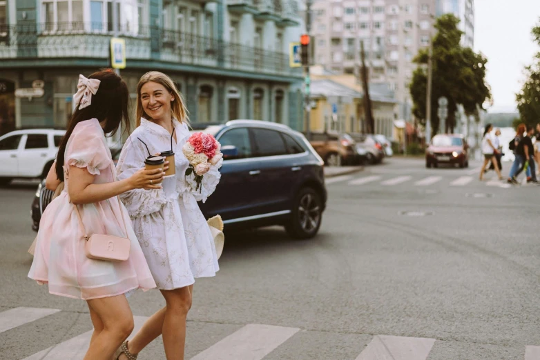 a pair of young women walking across a cross walk