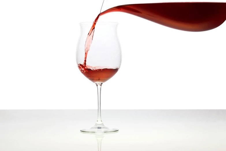 a glass of wine that is pouring it in