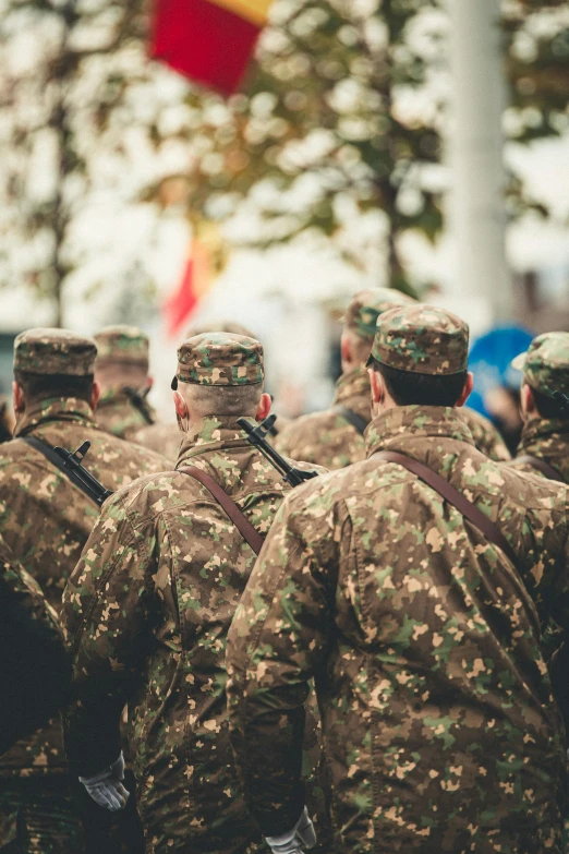 several people wearing military fatigues and carrying a bunch of bags