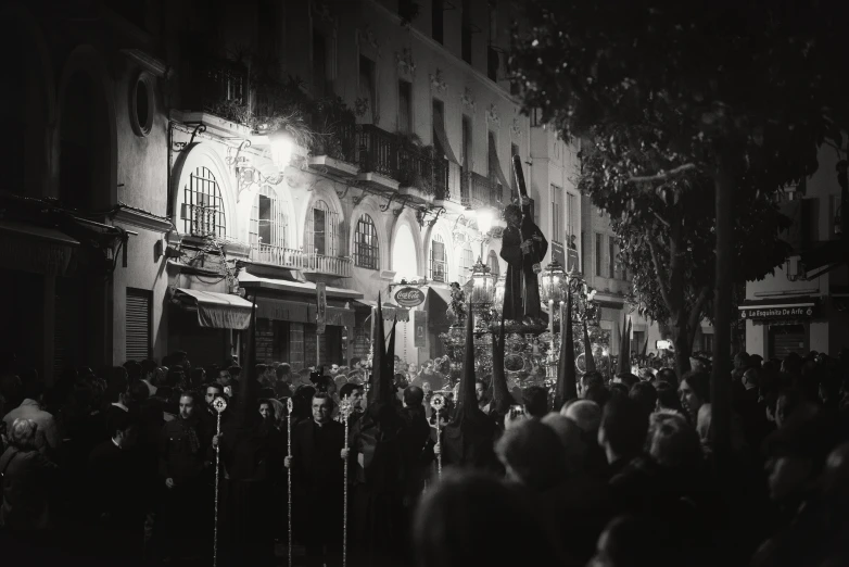 a group of people walking down a street in the night