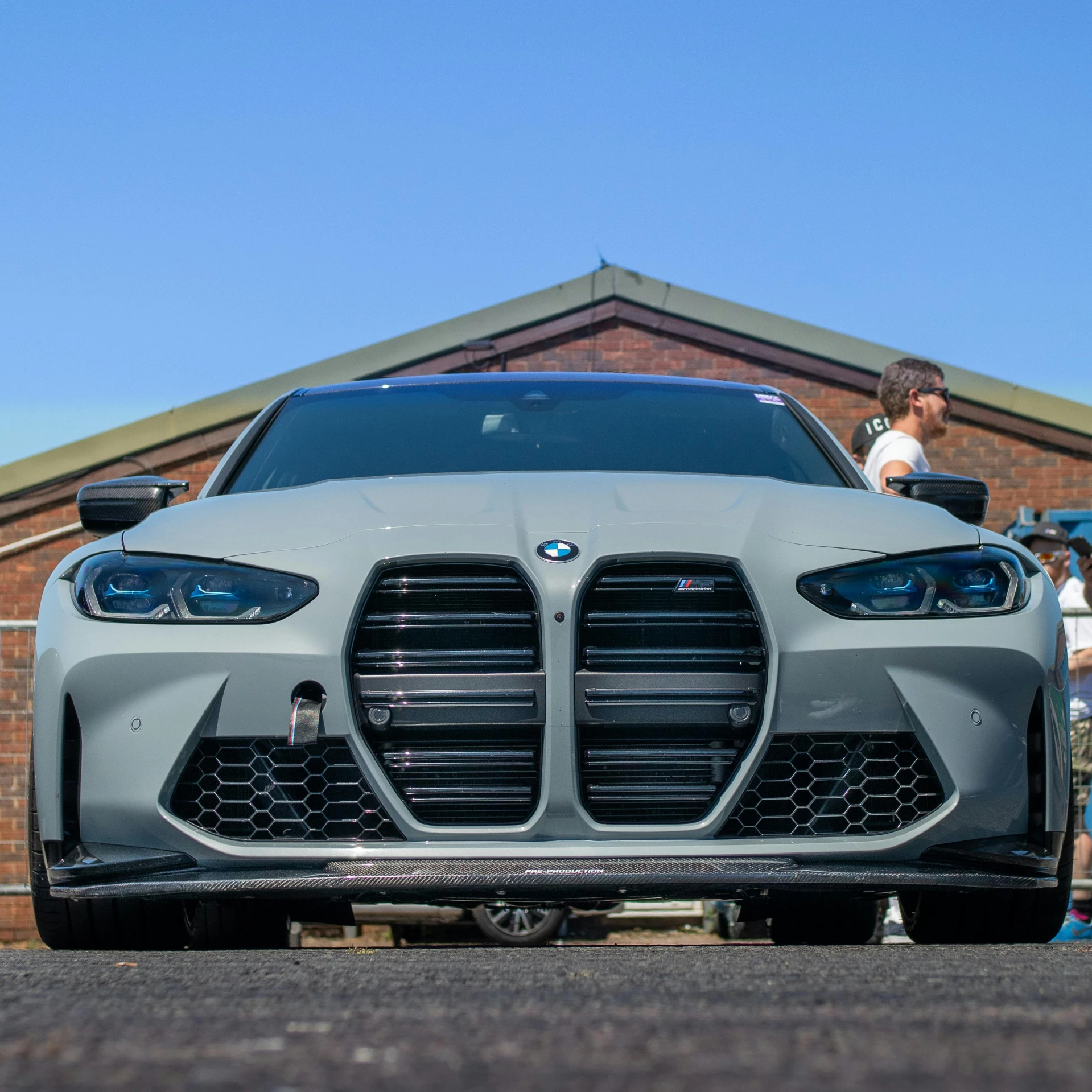 a silver sports car sits parked in front of people