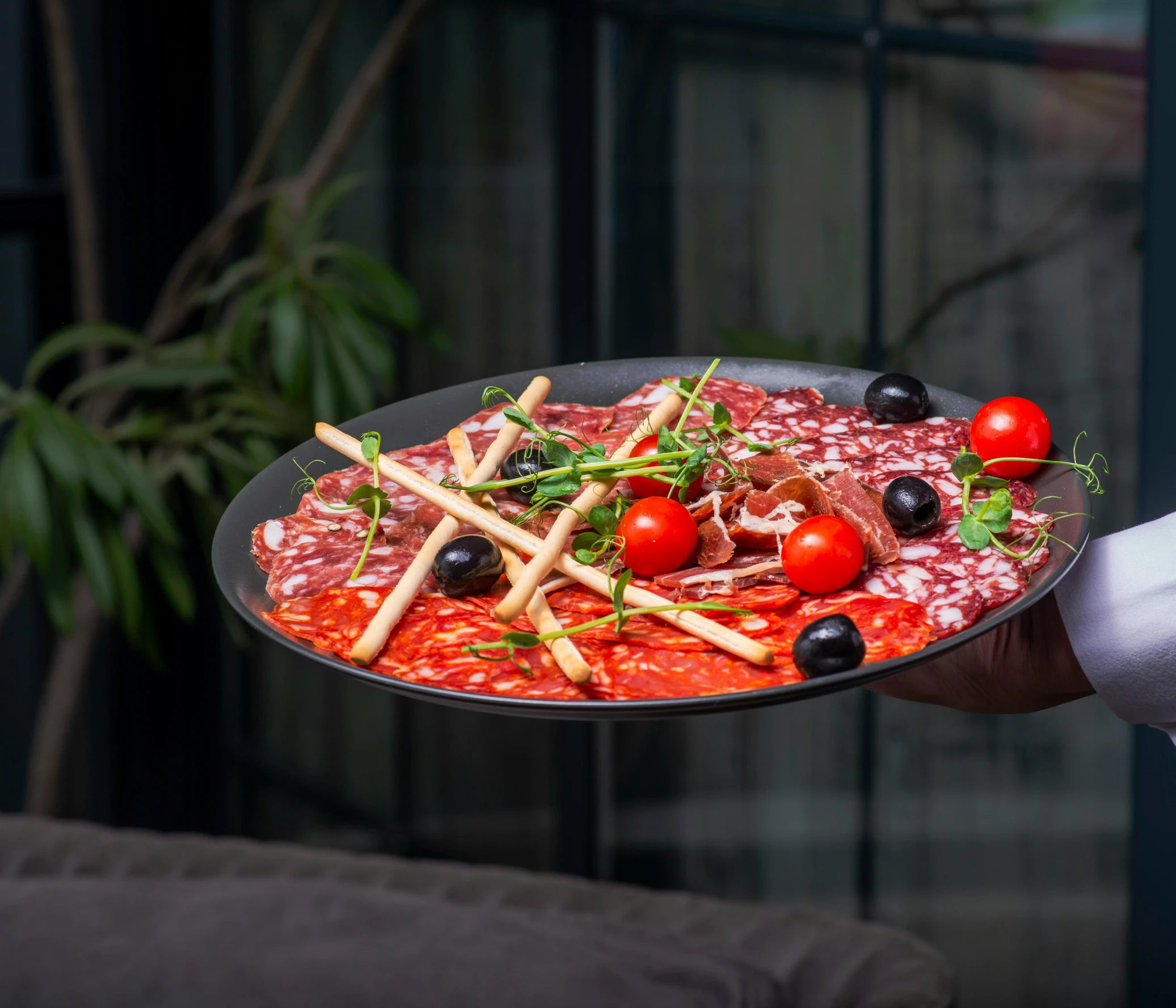 someone holding an iron tray filled with different foods