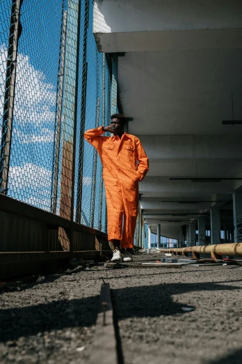 a person in an orange coat standing on a bridge