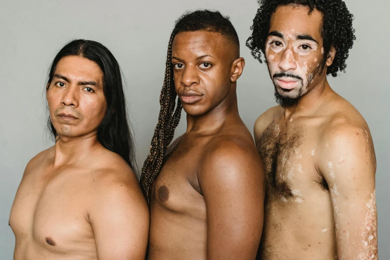 three men standing shirtless posing for a picture