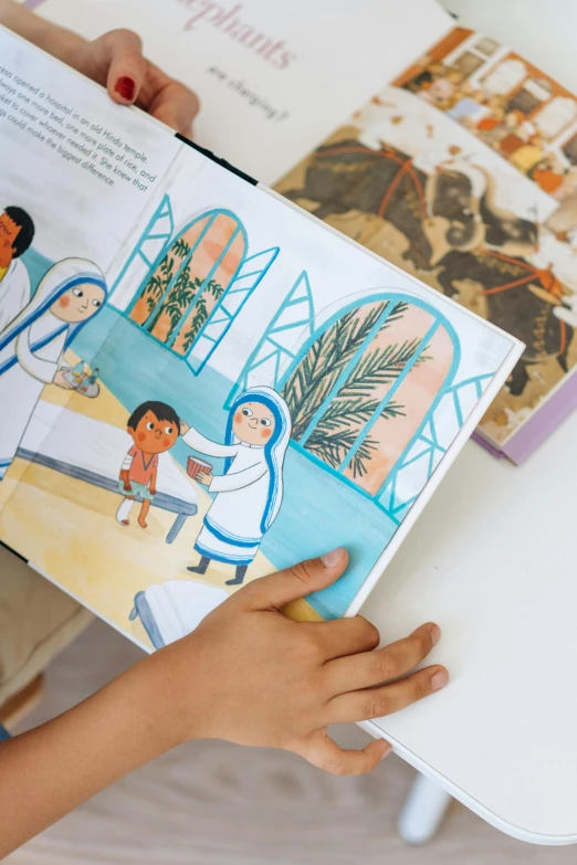 hand holding an illustrated children's book open to a story