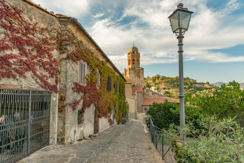 an alley leading to a building with a clock tower