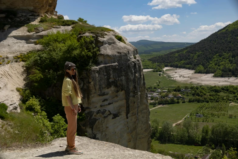 a person standing in front of a cliff and valley