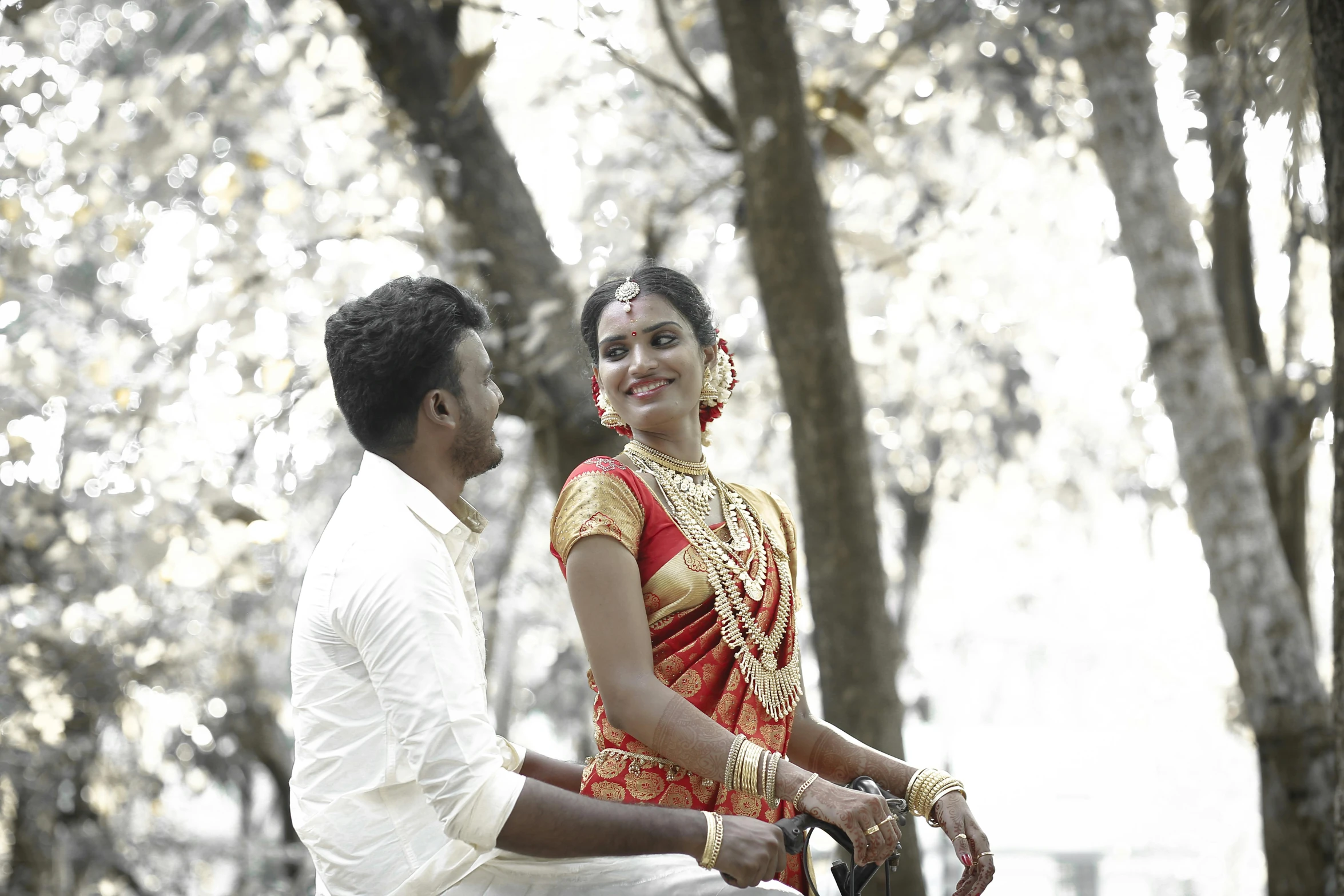 a man holds the hand of a woman in a red and gold dress