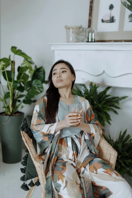 a woman sitting on a chair next to potted plants