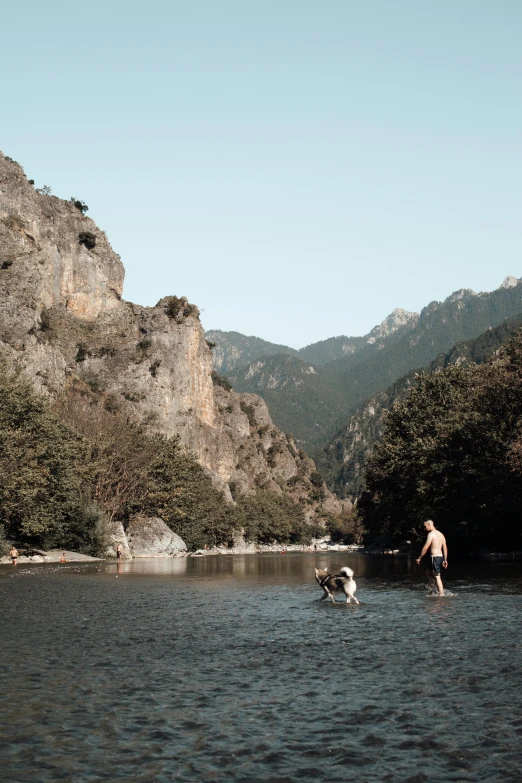 a person floating in a lake next to mountains