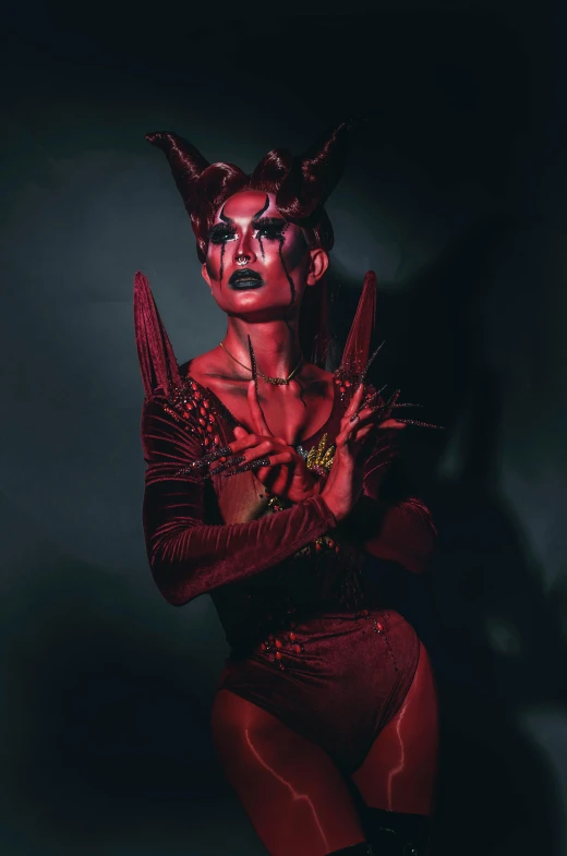 a woman in a bodysuit with red hair and horns on
