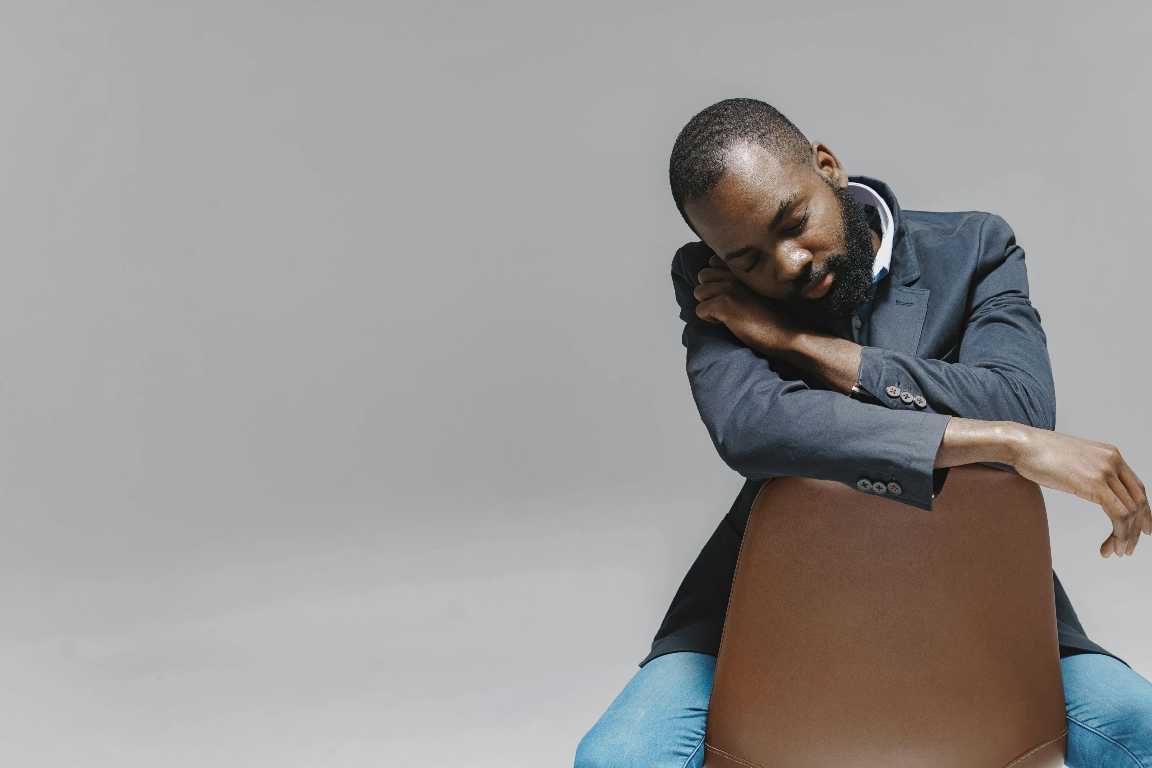 a man sitting on a wooden table, in a suit