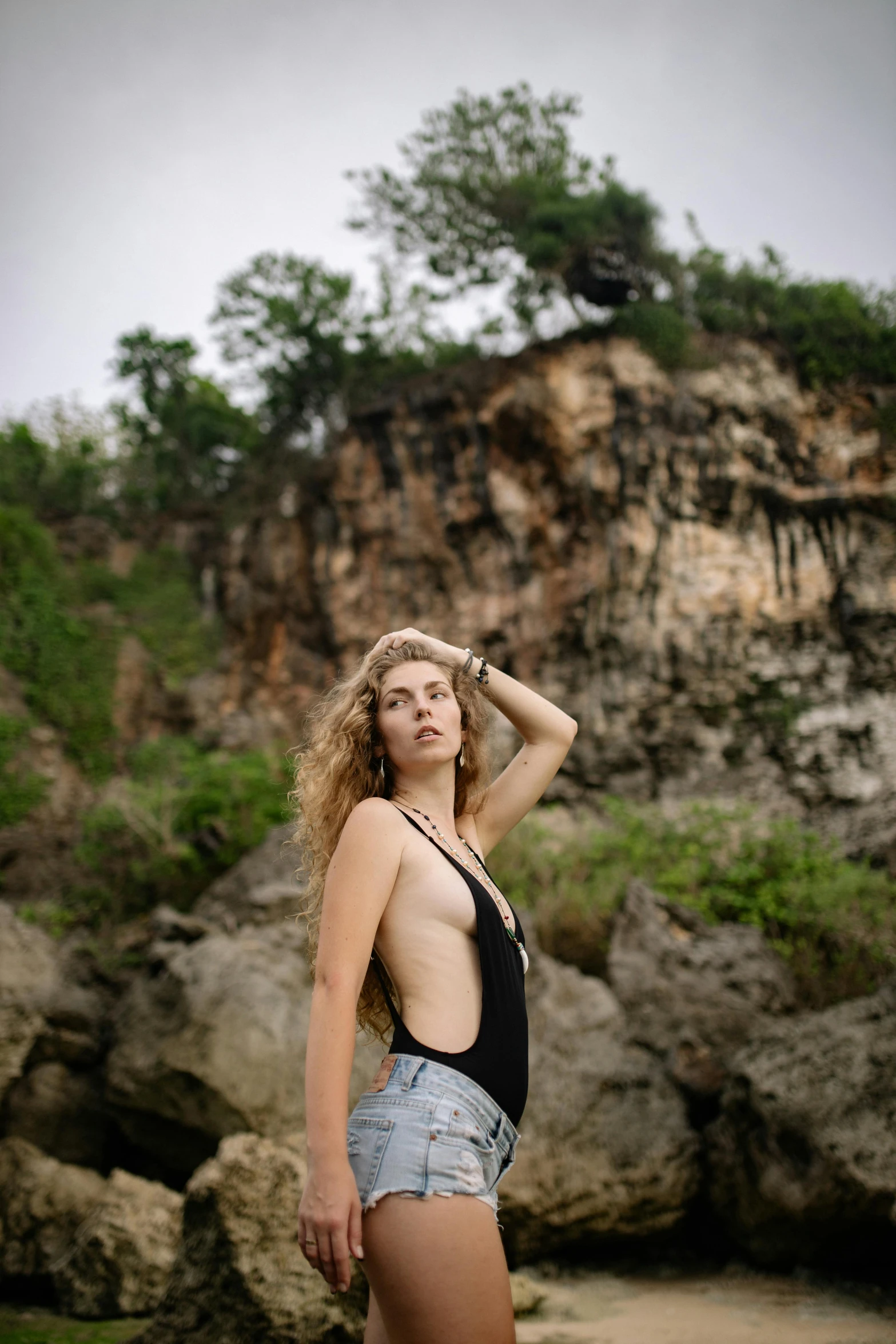 a woman in shorts is standing near some rocks