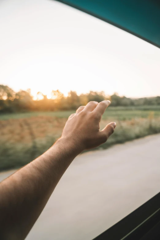 a hand that is outside the window on a vehicle