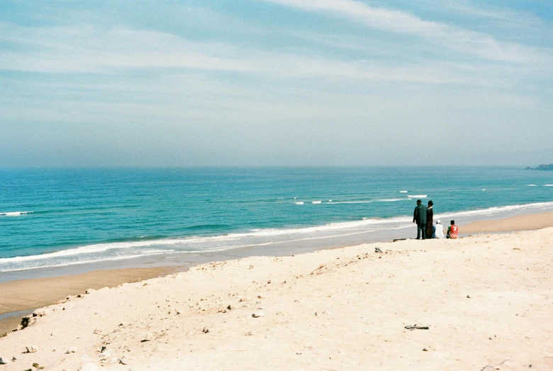 a man and woman walking down the beach