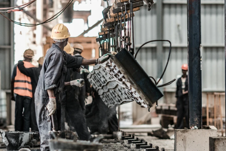 a worker checking the workings of a machine at a steel factory