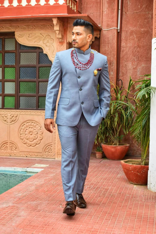 a man is walking in a suit in front of a building