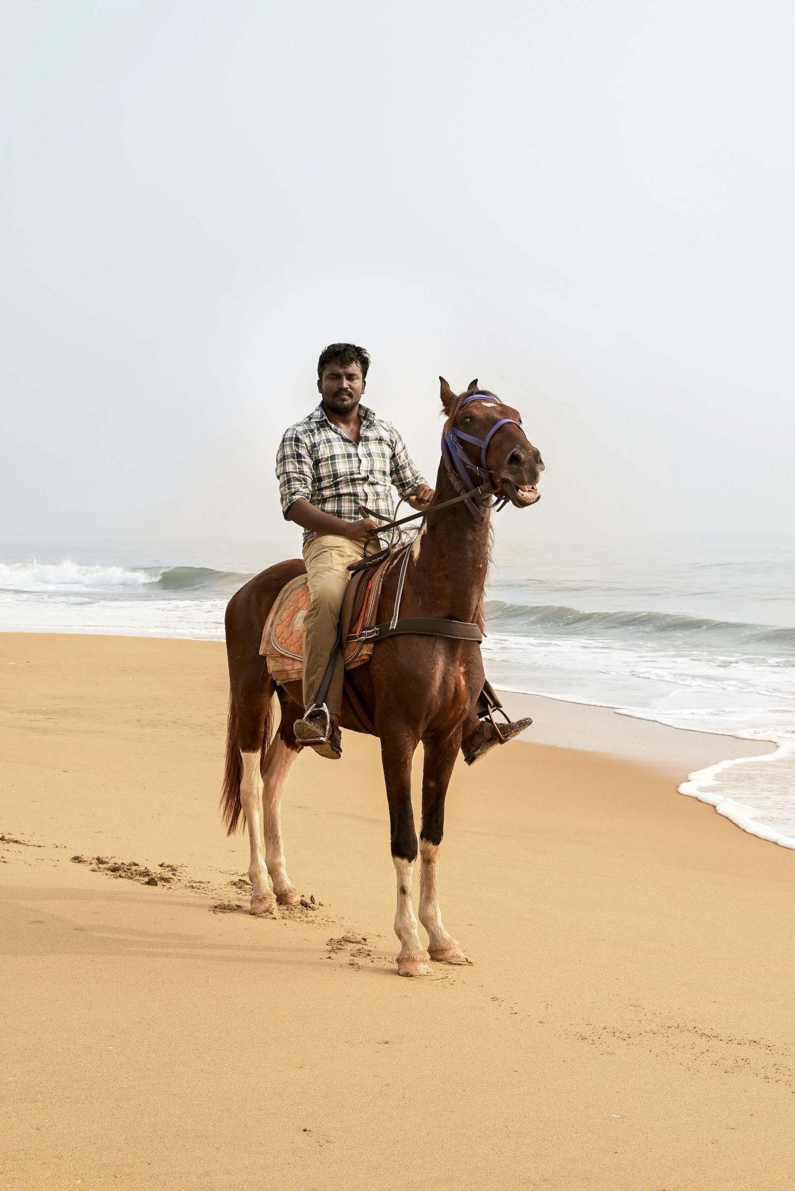 man riding on the back of a horse at the beach