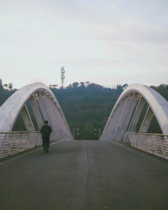 a person walking across a bridge on a road