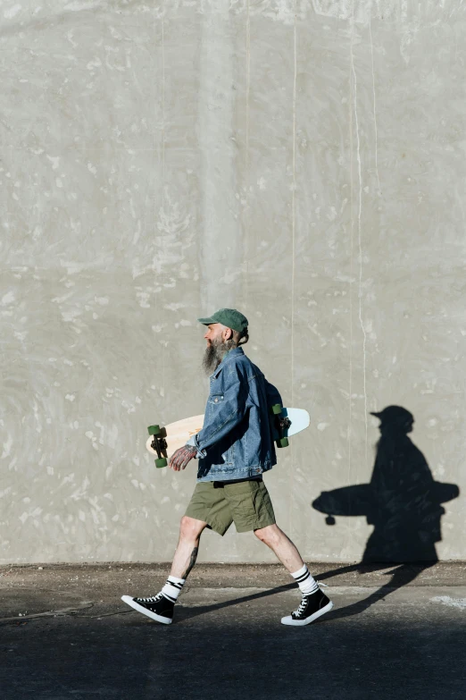 a man walking in the road with his skateboard