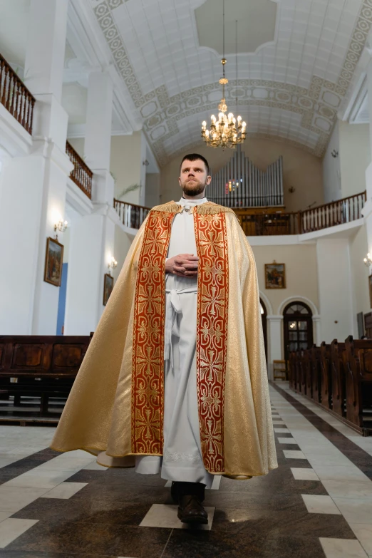 man in priest outfit standing in large church