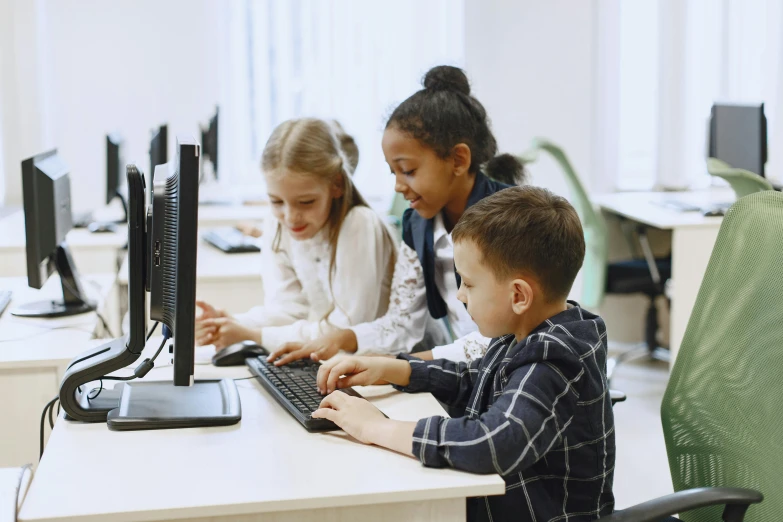 children using computers at desk in an office