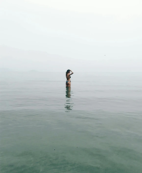 a person standing on the water looking up at the sky