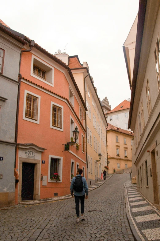 people are walking along a cobblestone street