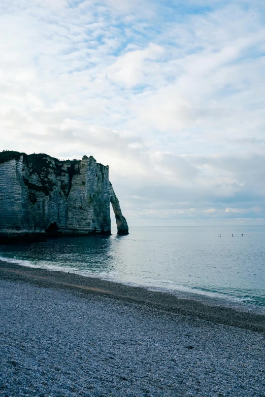 a beach with an interesting rock formation at the edge