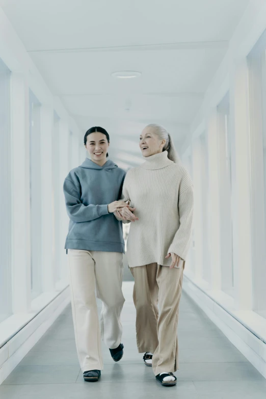 two asian women walking together in a corridor