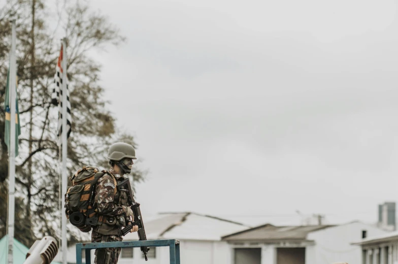 a soldier stands with his weapons out on the street