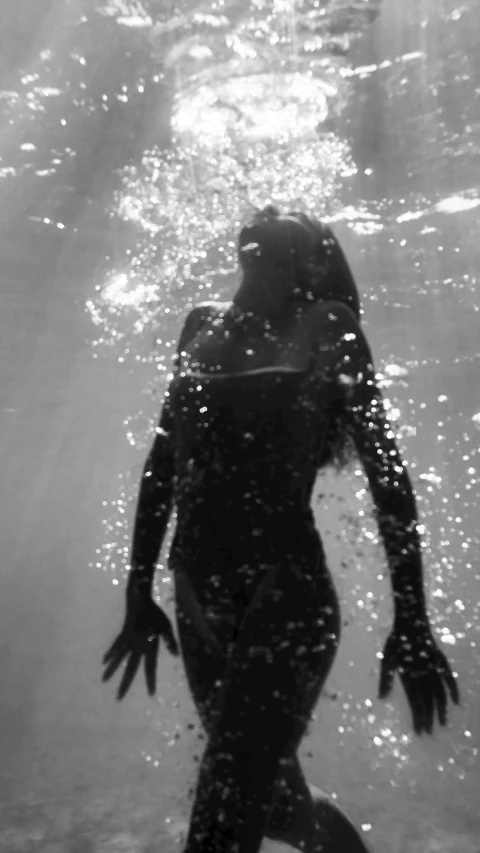 a man swims under water near shore lines