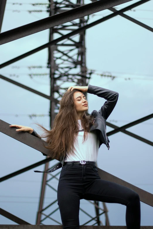 a woman is standing next to an electric tower