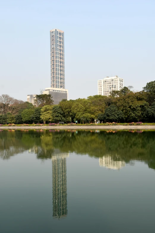 a city skyline with a large building reflecting in the water