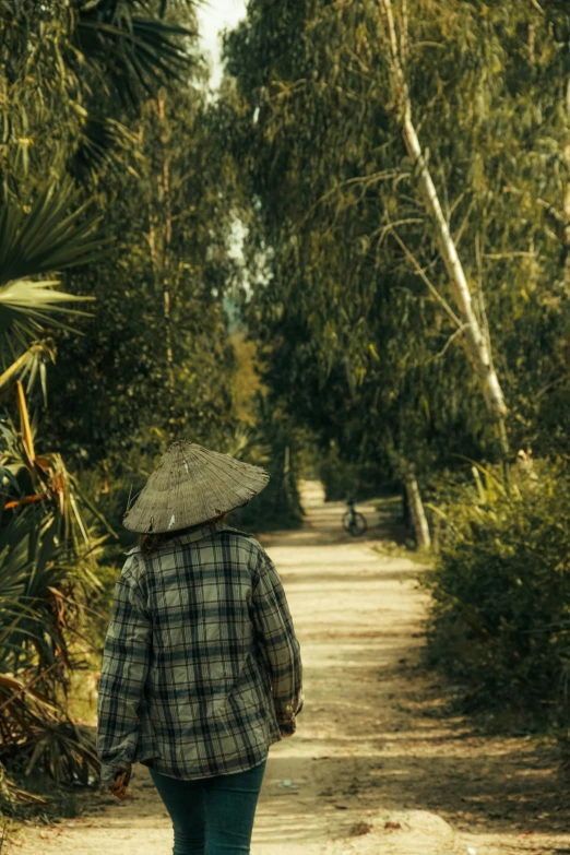 the woman in a plaid shirt is walking down the road