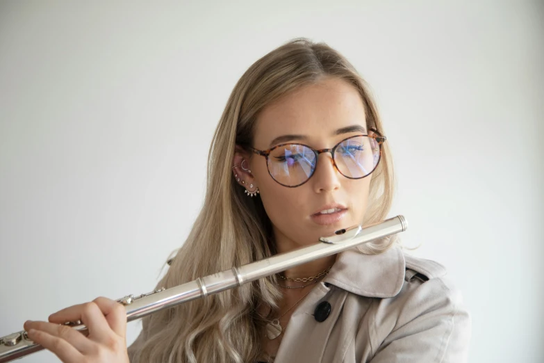 a beautiful young blond woman holding a metal object in her hand