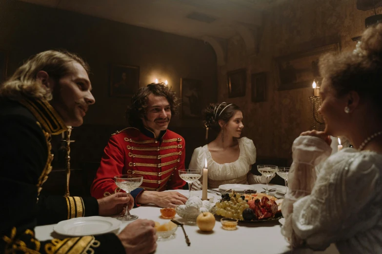 three people sitting at a dinner table and wearing uniforms