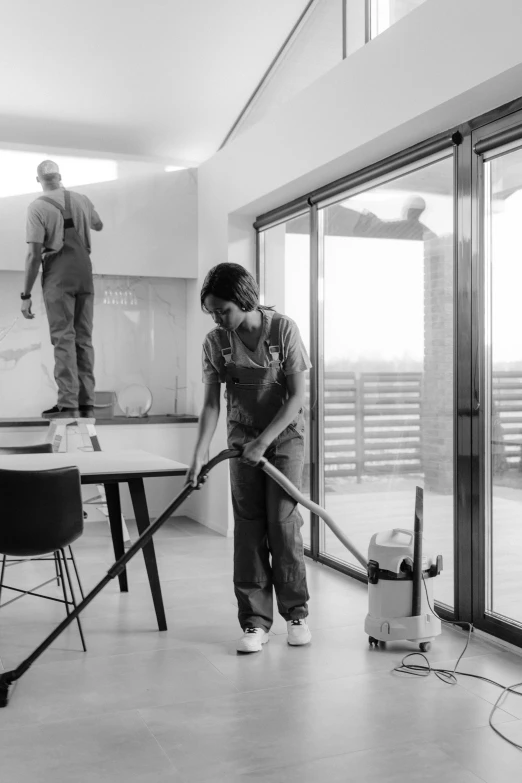 a woman with a vacuum mop in a room