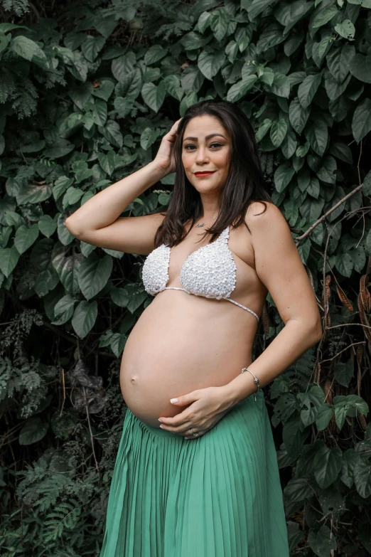 a pregnant woman in a  with green dress and skirt