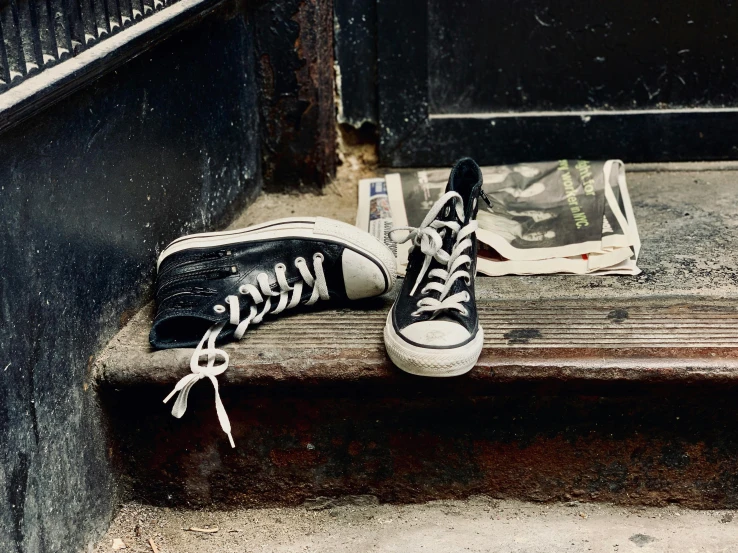 a pair of sneakers and newspaper on the steps