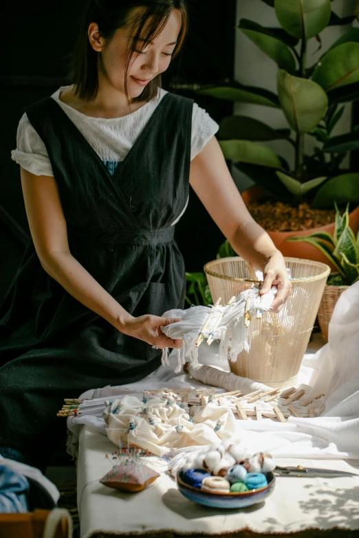 young woman in black dress in front of table filled with shells