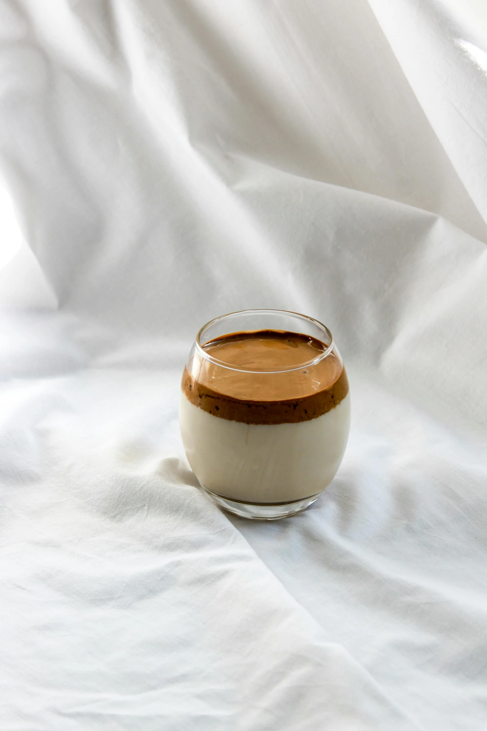 a jar filled with a liquid on top of a white cloth