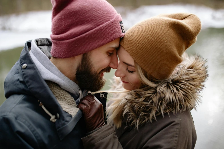 man and woman emcing on the ice by a river