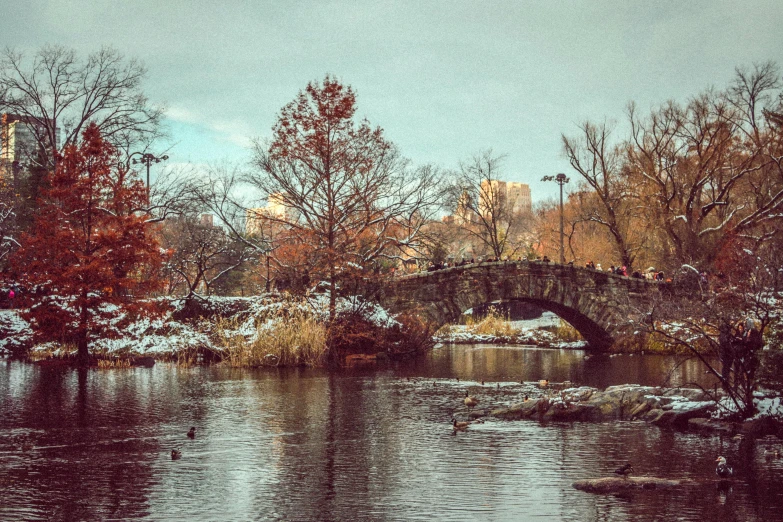 an artistic po of an old stone bridge over a lake