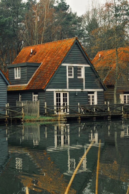 a water front house with orange roofs sits alone