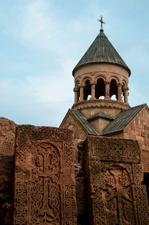 a building with carvings on it has a small tower with a cross