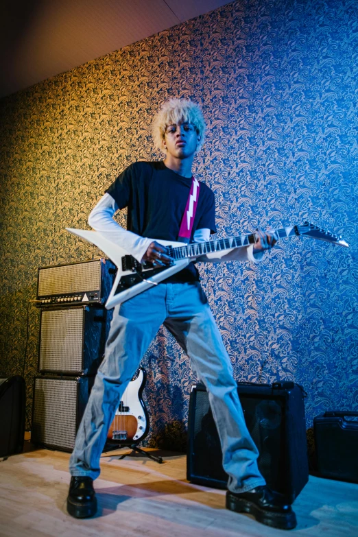 the musician is playing his electric guitar in a blue lit room