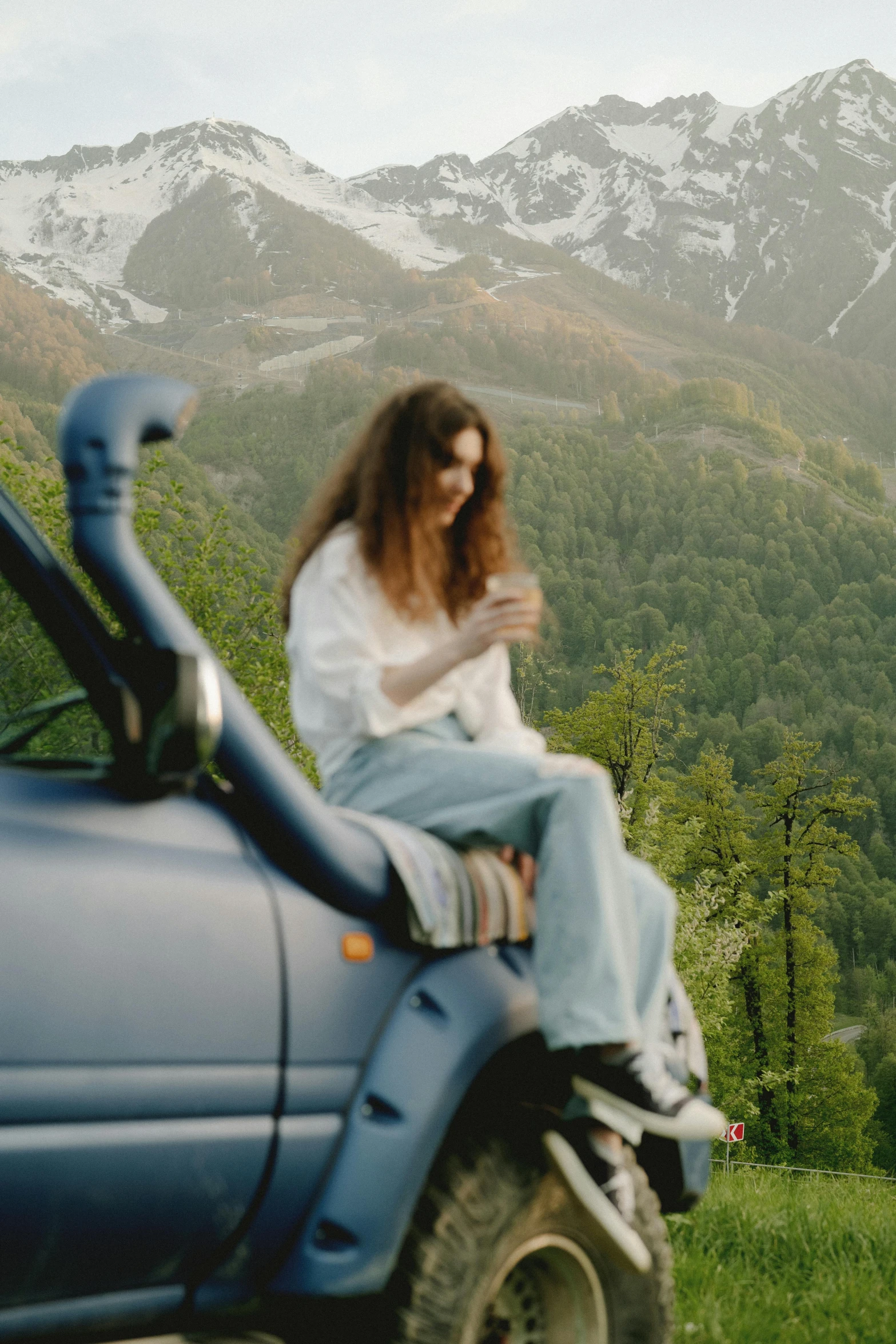 the woman is sitting on top of a vehicle